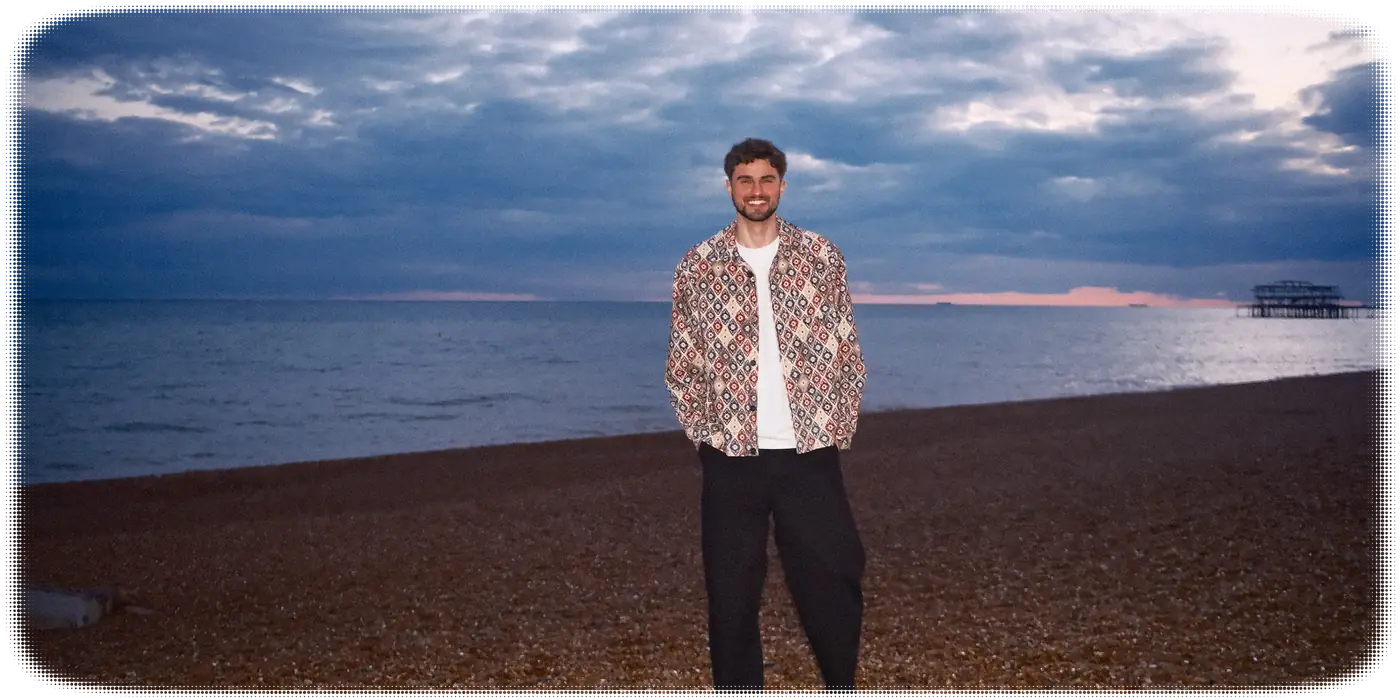Tyler standing on Brighton beach at dusk